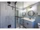 Modern bathroom with gray cabinets, a glass shower, and hexagon mirrors at 18459 Sw 66Th Loop, Dunnellon, FL 34432