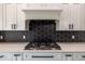 Stainless steel gas cooktop with modern range hood and white cabinets at 18459 Sw 66Th Loop, Dunnellon, FL 34432