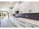 Modern kitchen with white shaker cabinets, quartz countertops, and a black hexagon backsplash at 18459 Sw 66Th Loop, Dunnellon, FL 34432