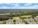 Aerial view of a beautiful home with a golf course and lake nearby at 1957 Turnbull Lakes Dr, New Smyrna Beach, FL 32168