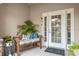 Front entry with wood bench, potted plants, and white door at 1957 Turnbull Lakes Dr, New Smyrna Beach, FL 32168