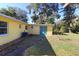 View of back patio and yard with lush landscaping at 1975 Lake Dr, New Smyrna Beach, FL 32168