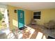 Inviting front porch with teal door, tile flooring and wooden chairs at 1975 Lake Dr, New Smyrna Beach, FL 32168