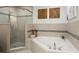 Bathroom with a shower, soaking tub, and tile surround, for a luxurious experience at 2 Riverwalk Dr # 402, New Smyrna Beach, FL 32169