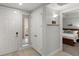 Hallway leading to bedroom with wood-look flooring, white trim and neutral paint at 2 Riverwalk Dr # 402, New Smyrna Beach, FL 32169