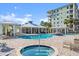 Exterior view of a pool and hot tub with palm trees, a grilling area, and covered seating at 2 Riverwalk Dr # 402, New Smyrna Beach, FL 32169