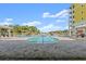 Exterior view of a pool with lounge chairs and a glimpse of a nearby pond at 2 Riverwalk Dr # 402, New Smyrna Beach, FL 32169