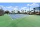 Well-maintained tennis court with lush green surroundings and exterior view of the building at 2 Riverwalk Dr # 402, New Smyrna Beach, FL 32169