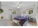 Cozy bedroom features floral accents, a ceiling fan, and natural light from two windows at 2232 Swoope Dr, New Smyrna Beach, FL 32168