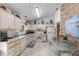 Bright eat-in kitchen featuring white cabinetry, tile flooring, and a brick accent wall at 2232 Swoope Dr, New Smyrna Beach, FL 32168