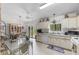 Bright kitchen featuring white cabinetry, tile flooring, a casual dining area, and sliding glass doors to the backyard at 2232 Swoope Dr, New Smyrna Beach, FL 32168