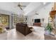 Inviting living room with cathedral ceilings, fireplace, tile floors, and views of the landscaped yard at 2232 Swoope Dr, New Smyrna Beach, FL 32168