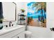 Modern bathroom with white vanity, freestanding tub, and beach-themed art at 224 Condict Dr, New Smyrna Beach, FL 32169