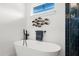 Bathroom with freestanding tub, dark blue tile, and a window at 224 Condict Dr, New Smyrna Beach, FL 32169