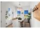 Bright dining room with white table, chandelier, and beach-themed art at 224 Condict Dr, New Smyrna Beach, FL 32169