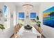 Bright dining room with white table, blue shutters, and coastal art at 224 Condict Dr, New Smyrna Beach, FL 32169