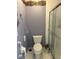 Standard toilet and shower with purple walls and decorative hooks at 2259 Candlewood E Ln, New Smyrna Beach, FL 32168