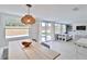 Dining area with light wood table, modern lighting, and backyard access at 2307 Saxon Dr, New Smyrna Beach, FL 32169