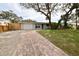 Light green house with brick driveway, and mature trees in the front yard at 2307 Saxon Dr, New Smyrna Beach, FL 32169