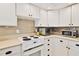 White kitchen with stainless steel appliances and mosaic backsplash at 2307 Saxon Dr, New Smyrna Beach, FL 32169