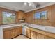 L-shaped kitchen with wood cabinets and white countertops at 2515 Fairfax Ave, New Smyrna Beach, FL 32168