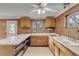 L-shaped kitchen with wood cabinets and white countertops at 2515 Fairfax Ave, New Smyrna Beach, FL 32168