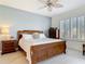 Bedroom with a wooden bed frame, ceiling fan, shutters, and a gray accent wall at 265 Minorca Beach Way # 204, New Smyrna Beach, FL 32169