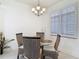 Dining area features neutral tones and a modern chandelier with natural light at 265 Minorca Beach Way # 204, New Smyrna Beach, FL 32169