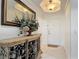 Elegant entryway with ornate console table, large mirror, and tiled floor leading to a white front door at 265 Minorca Beach Way # 204, New Smyrna Beach, FL 32169