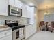 Modern kitchen featuring white cabinets, stainless steel appliances, and a view into the dining area at 265 Minorca Beach Way # 204, New Smyrna Beach, FL 32169