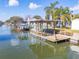 Private waterfront deck and dock with covered boat lift and seating area at 275 Randle Ave, Oak Hill, FL 32759