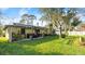 Backyard showing the grassy yard, a covered area with a grill, and mature trees that provide great shade at 2813 Sabal Palm Dr, Edgewater, FL 32141