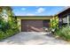 Exterior photo of the garage, including a shaded seating area and attractive lush landscape at 2813 Sabal Palm Dr, Edgewater, FL 32141