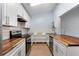 Modern kitchen featuring butcher block counters, white cabinets, subway tile backsplash, and stainless appliances at 2910 Oak Trail Run # 10, Port Orange, FL 32127