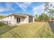 House exterior with a large grassy backyard and screened patio at 3012 Portofino Blvd, New Smyrna Beach, FL 32168