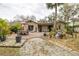 Expansive backyard featuring lush landscaping, brick paver patio with seating, and mature trees offering ample shade at 314 Hillman St, New Smyrna Beach, FL 32168