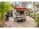 Outdoor patio with brick pavers, dining set with umbrella, and grill for outdoor entertainment and relaxation at 314 Hillman St, New Smyrna Beach, FL 32168
