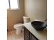 Bathroom featuring vessel sink on vanity, toilet, window, and tiled floor at 322 Canal Rd # 16, Edgewater, FL 32132