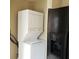 Laundry area with stackable washer/dryer and black refrigerator at 322 Canal Rd # 16, Edgewater, FL 32132