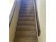 Carpeted staircase featuring railing and neutral paint at 322 Canal Rd # 16, Edgewater, FL 32132