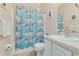 Clean bathroom with shower/tub combo, white vanity, and colorful shower curtain at 323 Mariners Gate Dr, Edgewater, FL 32141