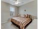 Spacious bedroom with striped bedding, ceiling fan, and ample natural light at 323 Mariners Gate Dr, Edgewater, FL 32141