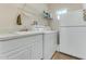 Bright laundry room with washer, dryer, sink, and overhead shelving at 323 Mariners Gate Dr, Edgewater, FL 32141