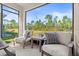 Relaxing screened porch with outdoor furniture, offering a view of the backyard at 3257 Carpentaria Dr, New Smyrna Beach, FL 32168