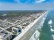 An expansive aerial view of the beachfront community, showcasing the coastline, beach, and nearby residential area at 3405 S Atlantic Ave # 501, New Smyrna Beach, FL 32169