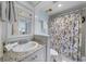 Nautical themed bathroom with granite counters, patterned shower curtain, and decorative mirror at 3405 S Atlantic Ave # 501, New Smyrna Beach, FL 32169