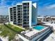 An exterior view of a multi-story condo building featuring a swimming pool and balconies overlooking the beach at 3405 S Atlantic Ave # 501, New Smyrna Beach, FL 32169