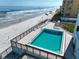 Elevated view of a pool with the ocean and beach in the background at 3405 S Atlantic Ave # 501, New Smyrna Beach, FL 32169