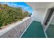 Private balcony overlooking lush vegetation and a glimpse of the ocean at 3641 S Atlantic Ave # 221, Daytona Beach, FL 32118