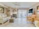 Well-lit living room with tile floors, fan, beach house decor, and sliding doors to balcony at 3700 S Atlantic Ave # 108, New Smyrna Beach, FL 32169